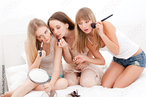 Group of women applying makeup on face