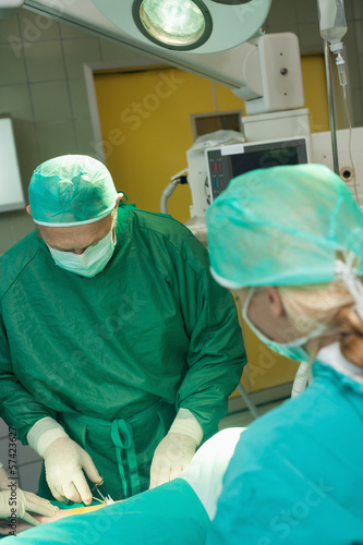 Surgeon holding scissors while operating