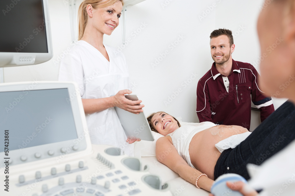 Fototapeta premium Doctor Showing Digital Tablet To Expectant Couple