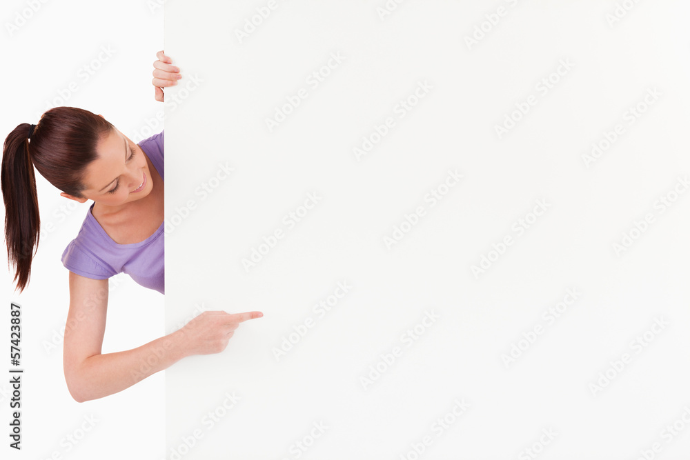 Cute female pointing at a copy space while standing Cute female pointing at a copy space while standing