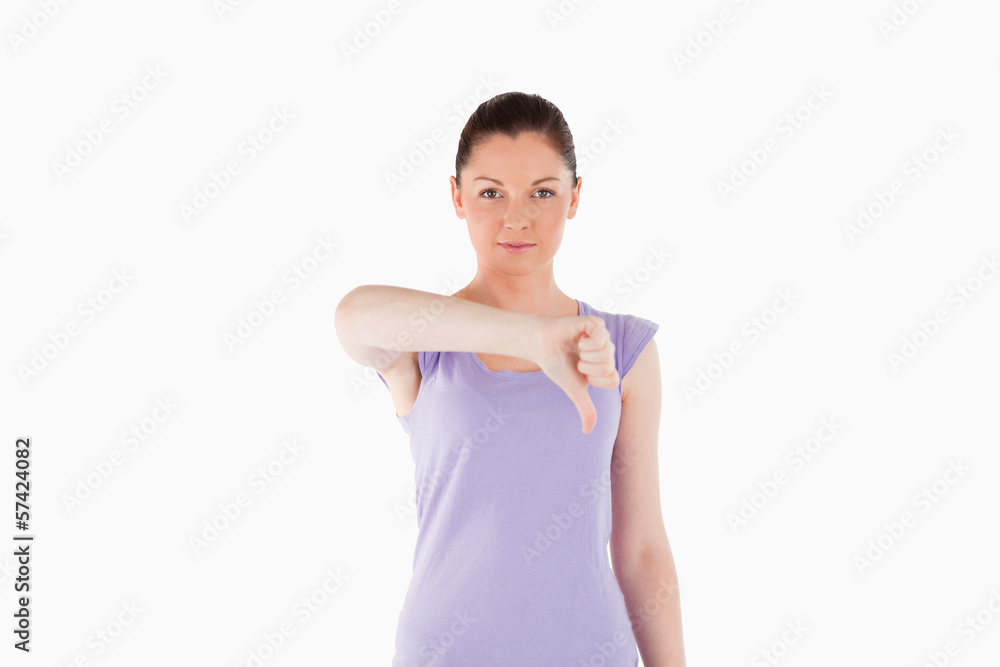 Good looking woman pointing her thumb down while standing Good looking woman pointing her thumb down while standing