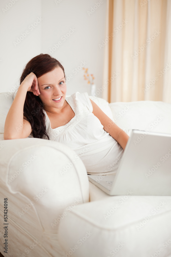 Beautiful red-haired woman relaxing on a sofa surfing the intern Beautiful red-haired woman relaxing on a sofa surfing the intern