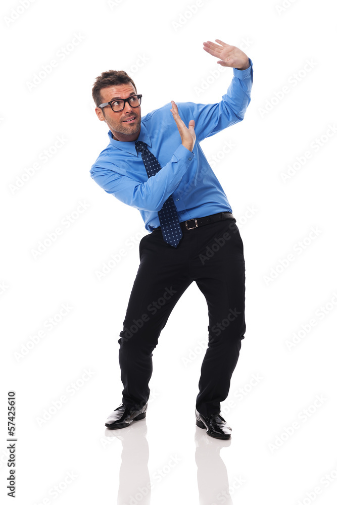 Scared businessman bending under the weight of something