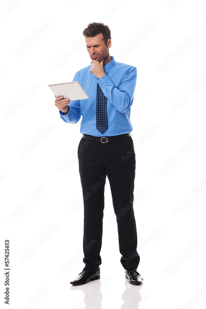 Businessman holding digital tablet and grimacing Businessman holding digital tablet and grimacing