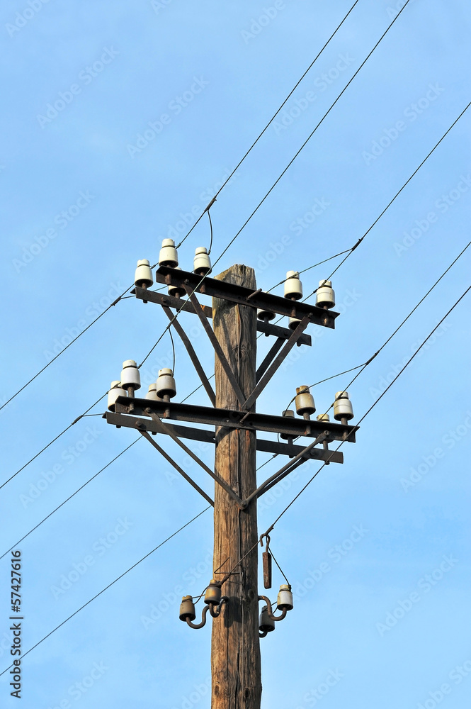 Old rural electric lines pylon on blue sky background Old rural electric lines pylon on blue sky background