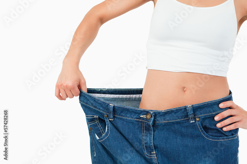 Fit woman wearing too large jeans