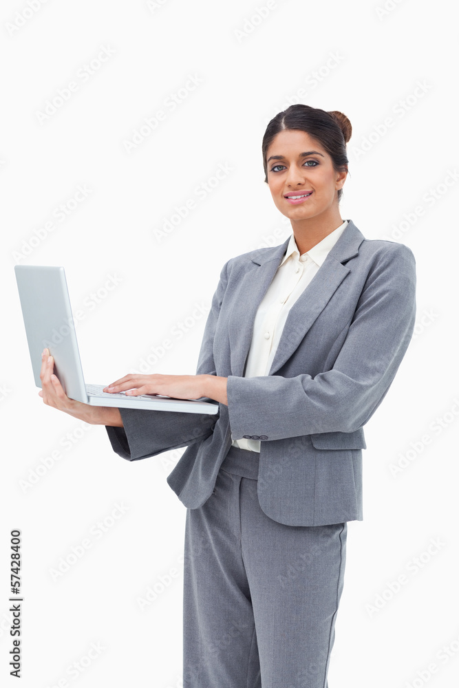 Smiling businesswoman using notebook while standing Smiling businesswoman using notebook while standing