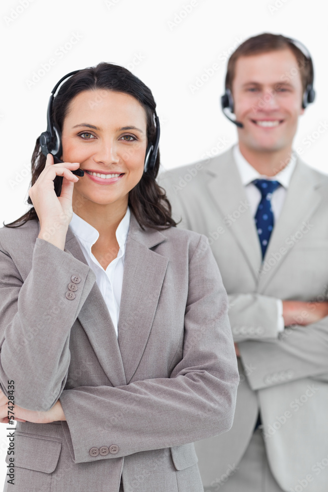 Smiling call center agents with headsets on and arms folded Smiling call center agents with headsets on and arms folded