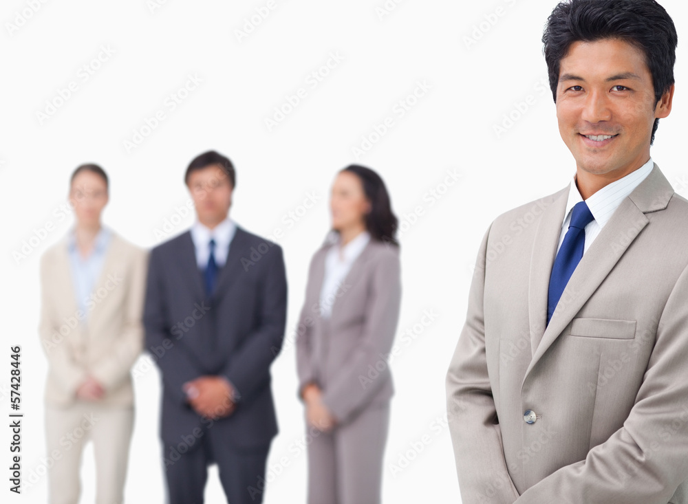 Businessman standing with his colleagues behind him Businessman standing with his colleagues behind him