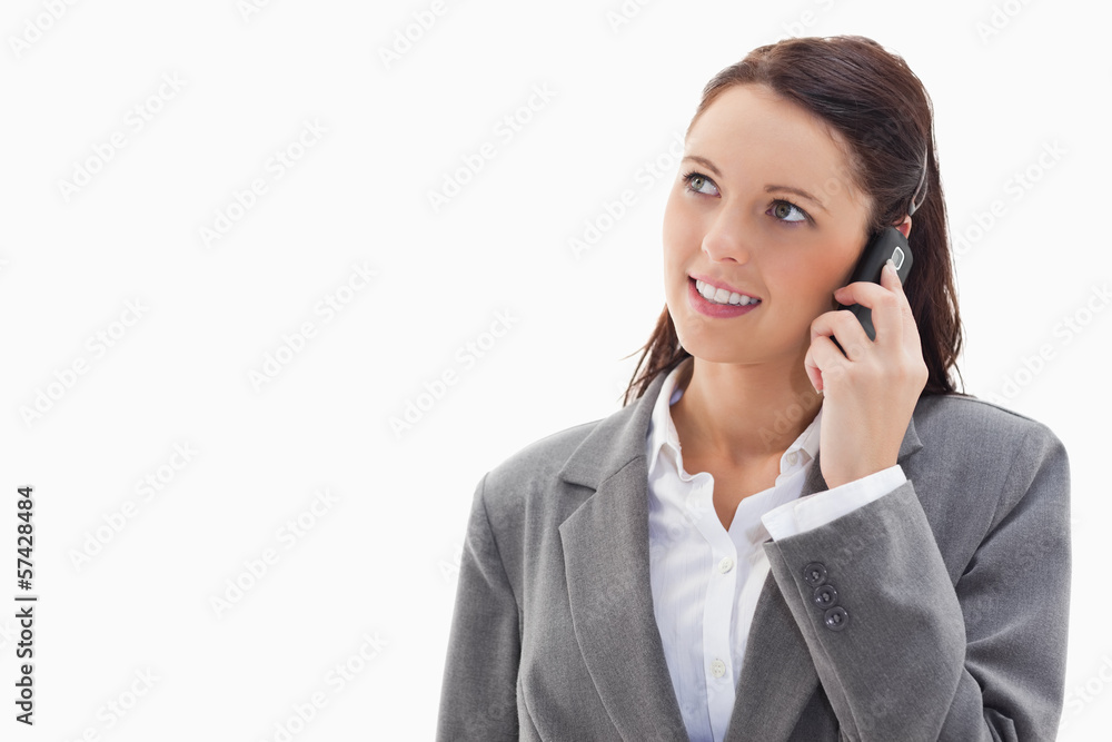 Close up of a businesswoman looking up while talking on the phon Close up of a businesswoman looking up while talking on the phon