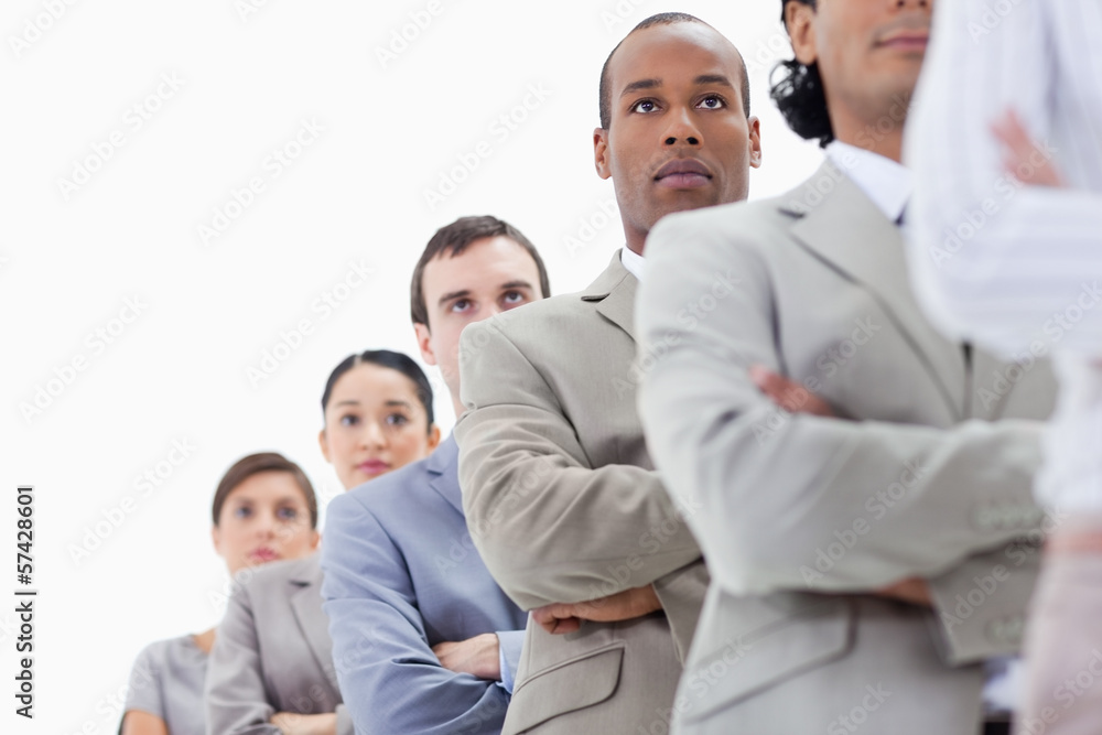 Low-angle shot of a serious business team crossing their arms in Low-angle shot of a serious business team crossing their arms in