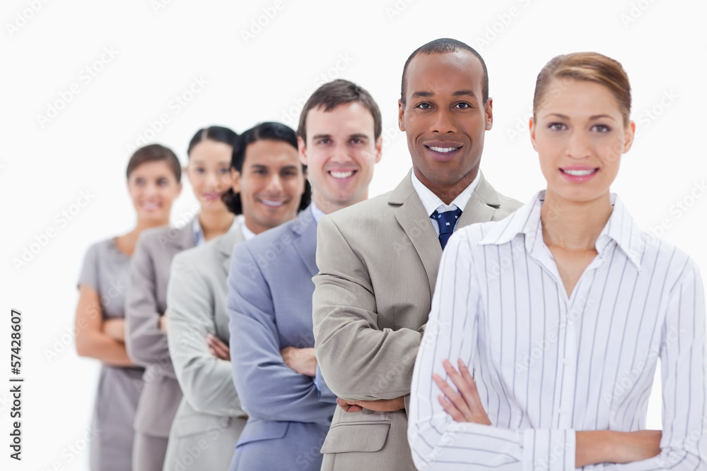 Close-up of smiling colleagues dressed in suits crossing their a Close-up of smiling colleagues dressed in suits crossing their a