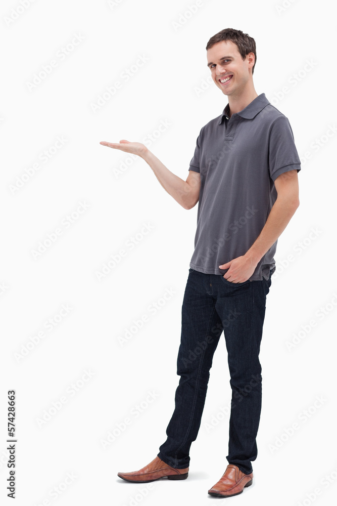 Happy man standing while holding his hand out Happy man standing while holding his hand out