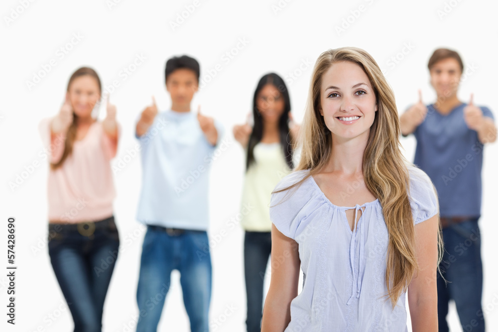 Close-up of woman smiling with people approving behind her Close-up of woman smiling with people approving behind her