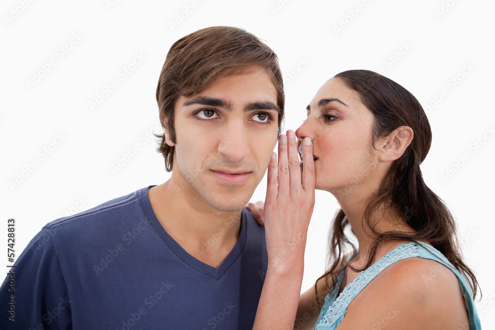Woman whispering something to her fiance Woman whispering something to her fiance