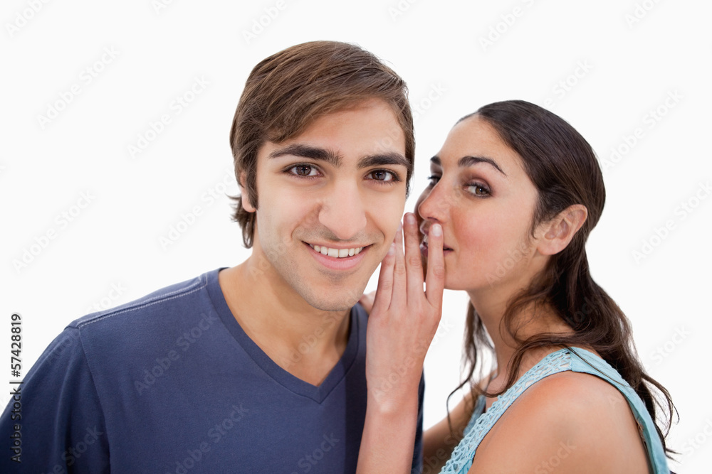 Young woman whispering something to her fiance Young woman whispering something to her fiance