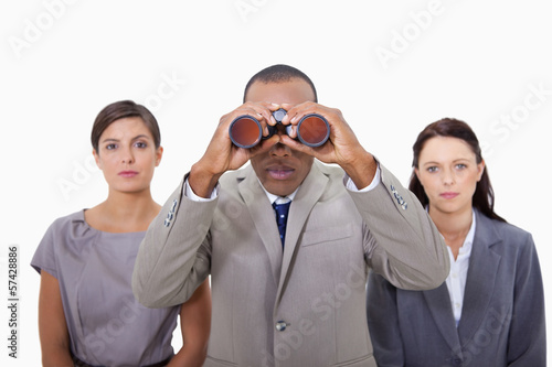 Businessman with colleagues using binoculars