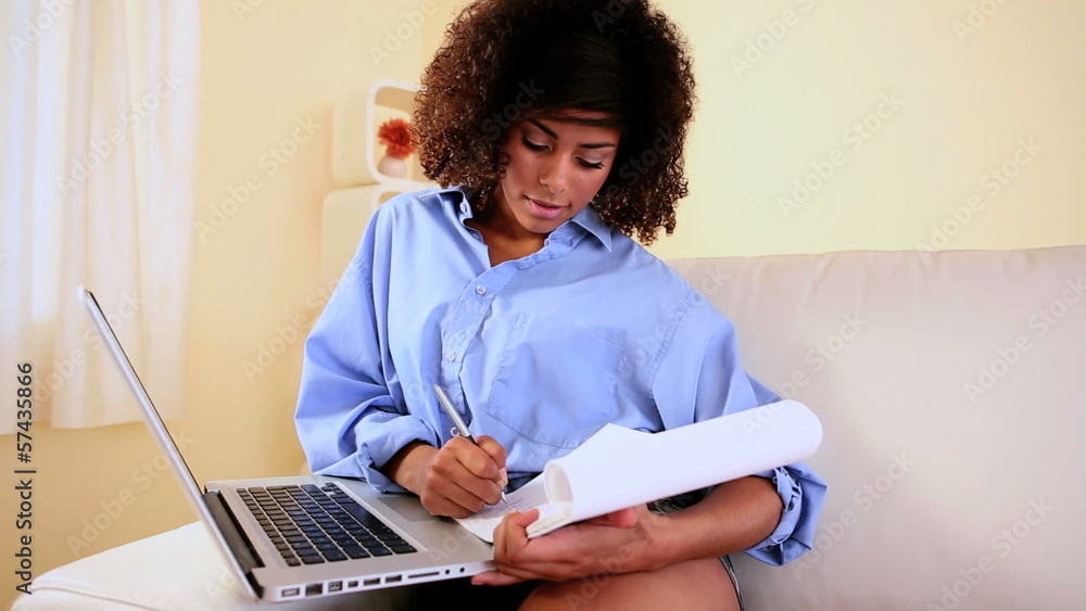 Gorgeous focused student sitting on couch studying Gorgeous focused student sitting on couch studying