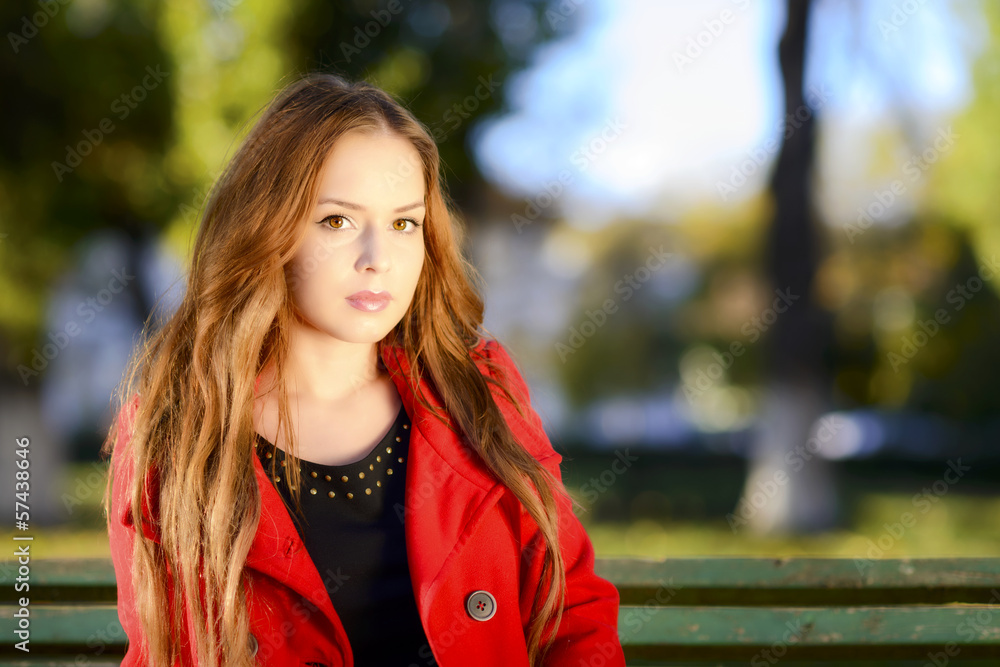 Beautiful elegant woman standing in a park in autumn Beautiful elegant woman standing in a park in autumn