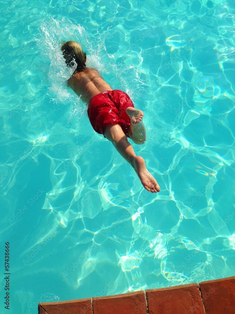 young boy diving in pool