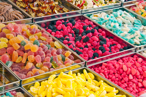 Présentoir de bonbons multicolores dans un magasin de confiserie, vente de sucreries colorées au poids en vrac