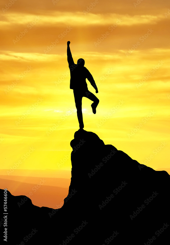 Silhouette of a winner on the mountain top Silhouette of a winner on the mountain top