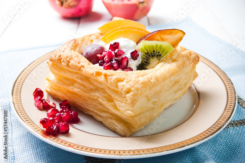 Delicious puff pastry with cream and fruits photo