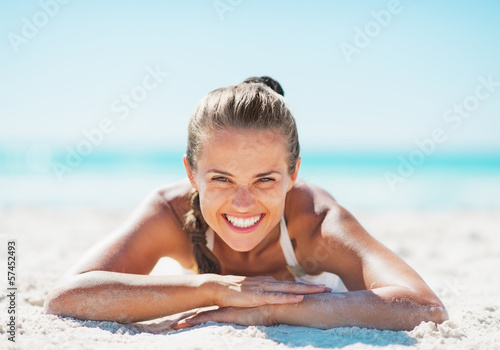 Konstfotografi Portrait of smiling woman in swimsuit laying on sandy beach