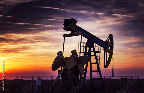Operating oil and gas well profiled on sunset sky photo