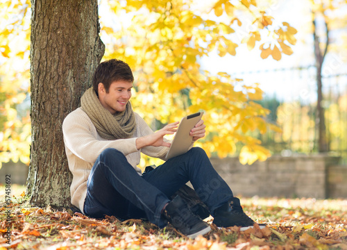 man with tablet pc in autumn park