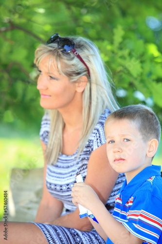 Happy family mother and son on bench in park