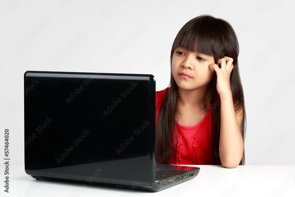Stressful little asian girl working on laptop Stressful little asian girl working on laptop
