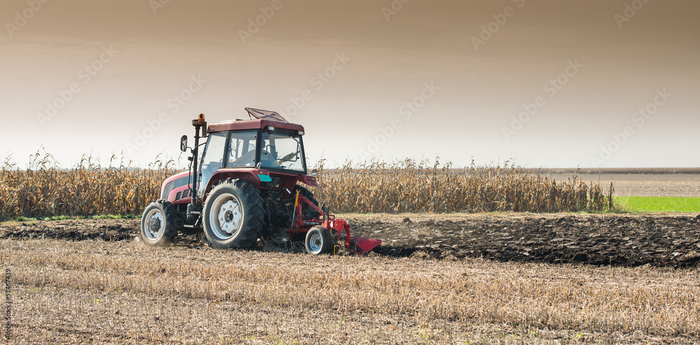 Obraz premium Tractor plowing field