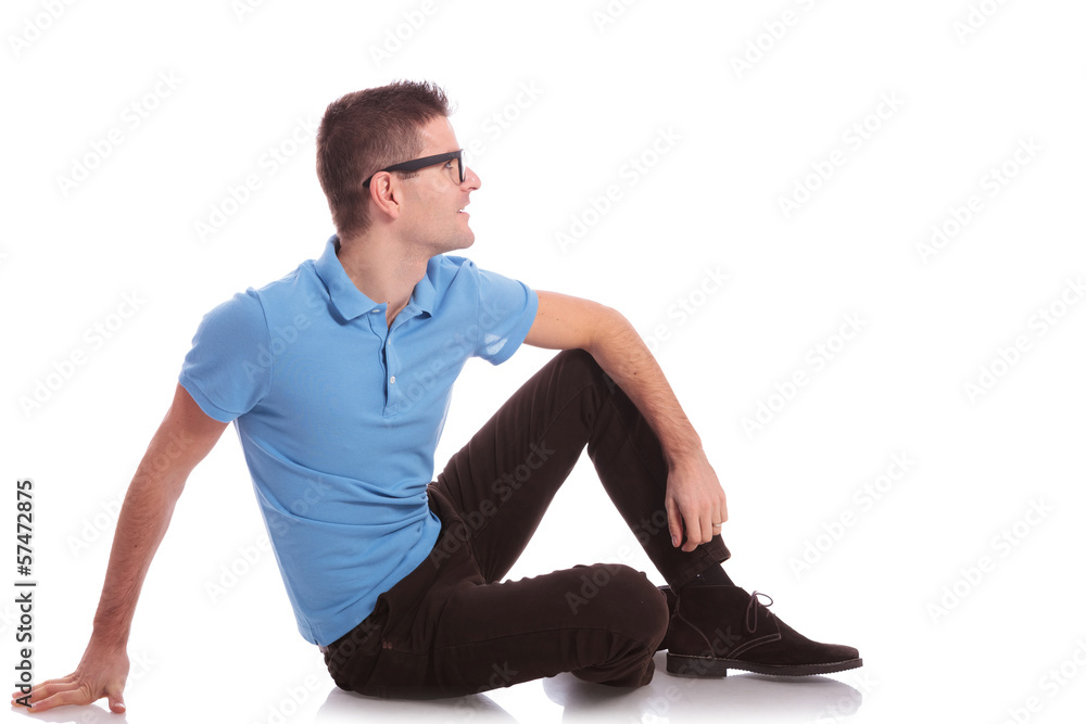 casual man lays on the ground and looks away casual man lays on the ground and looks away