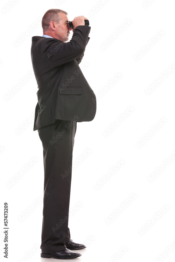 side of business man looking through binoculars side of business man looking through binoculars