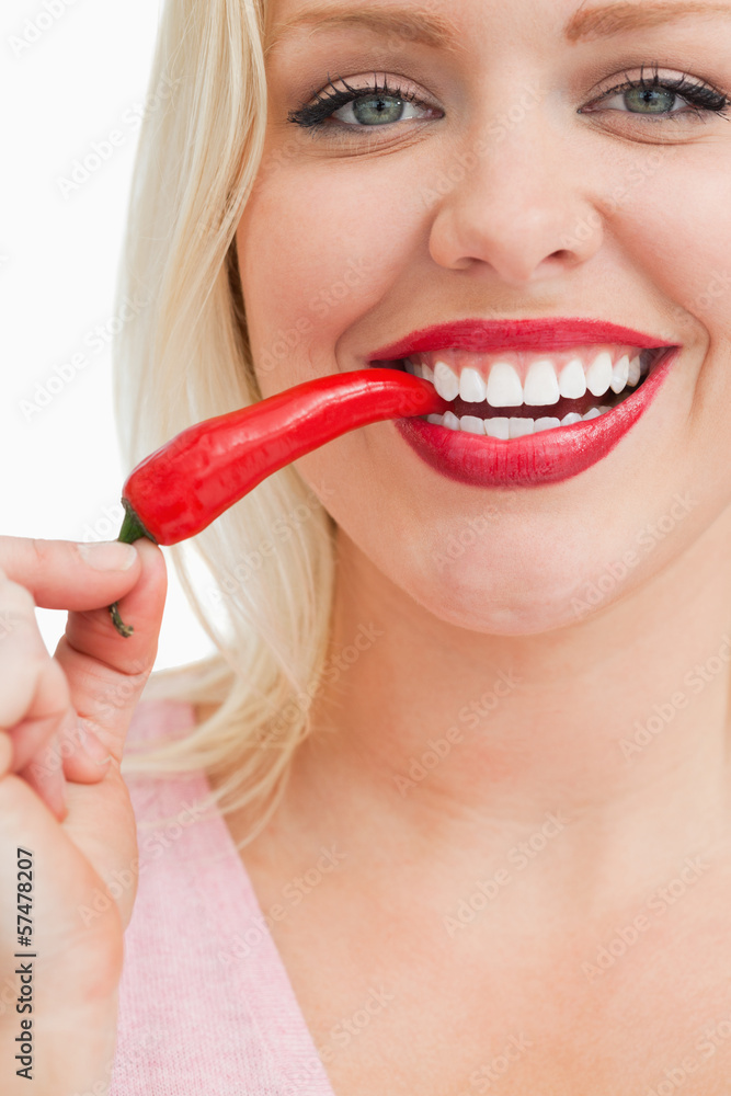 Cheerful blonde woman eating a chili Cheerful blonde woman eating a chili