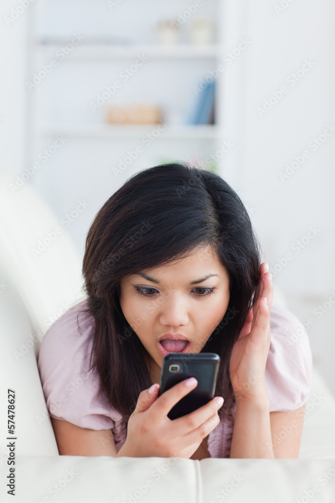 Chocked woman phoning while resting on a sofa Chocked woman phoning while resting on a sofa