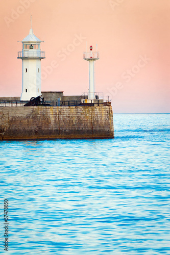 Seascape at sunrise. Lighthouse in the morning
