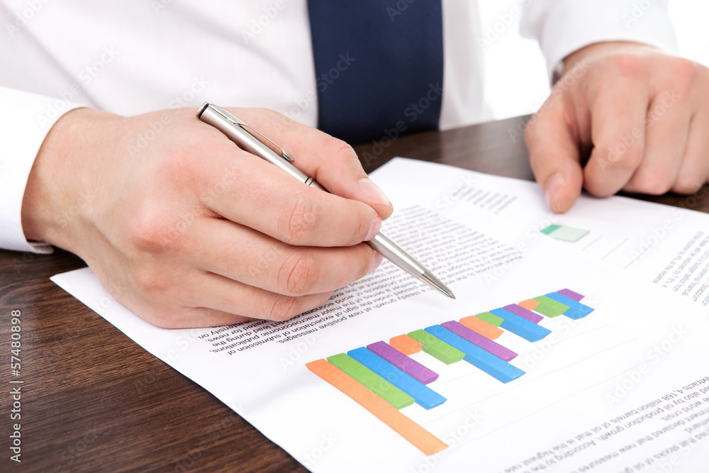 businessman in the office of the table points to the graphics businessman in the office of the table points to the graphics