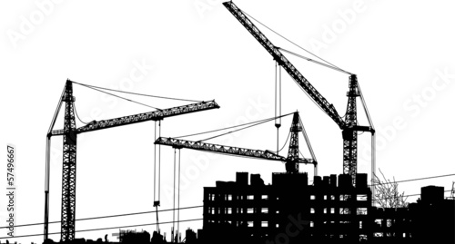 Silhouettes of two cranes near of building