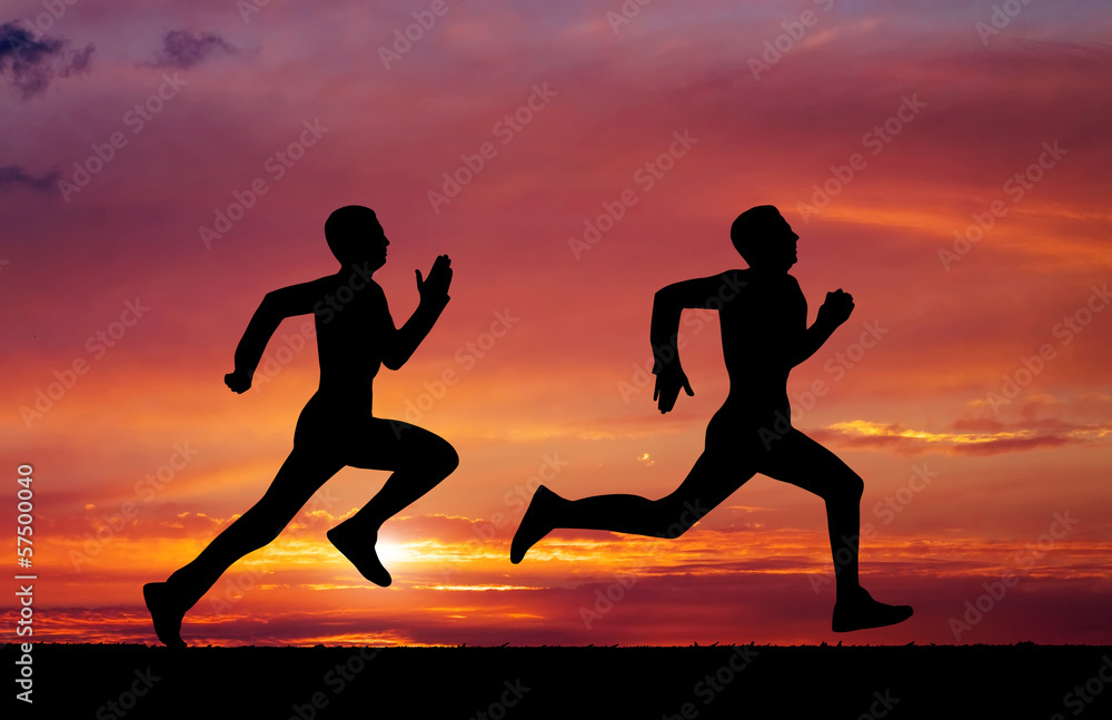 Silhouettes of two runners on sunset fiery background