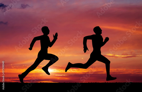 Silhouettes of two runners on sunset fiery background