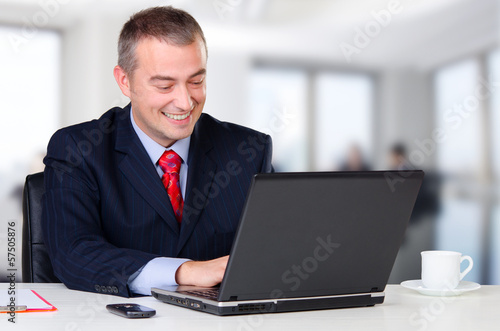 Young happy business man working on notebook