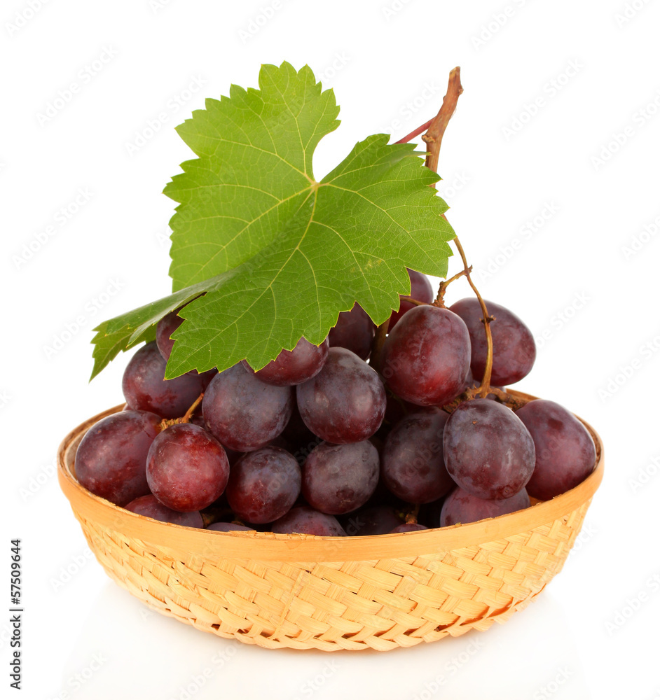Obraz premium Ripe delicious grapes in wicker basket isolated on white