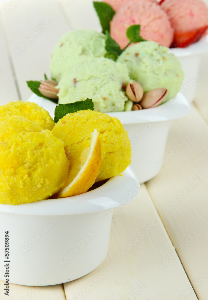 Tasty ice cream scoops in bowls, on wooden table Tasty ice cream scoops in bowls, on wooden table
