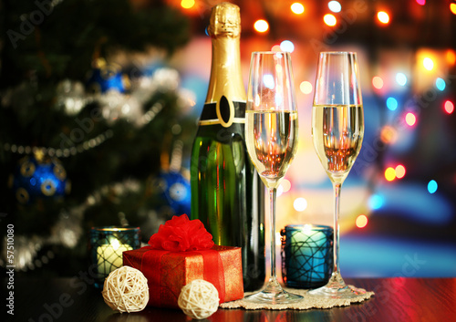Glasses of champagne and gifts on bright background
