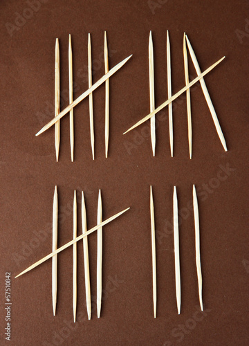 Toothpicks - counting days concept on brown background