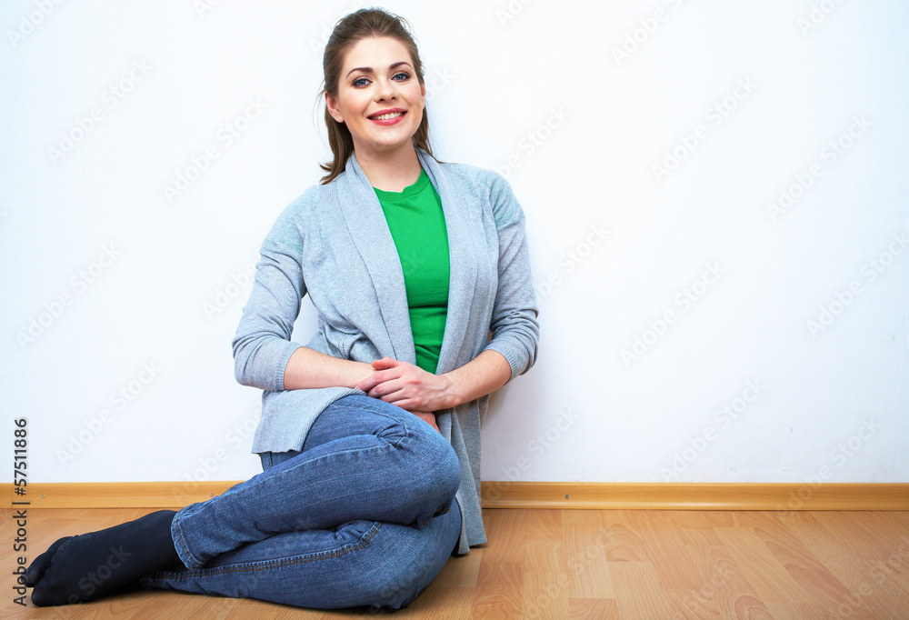 Fototapeta premium Woman natural portrait seatting on a floor. White background is