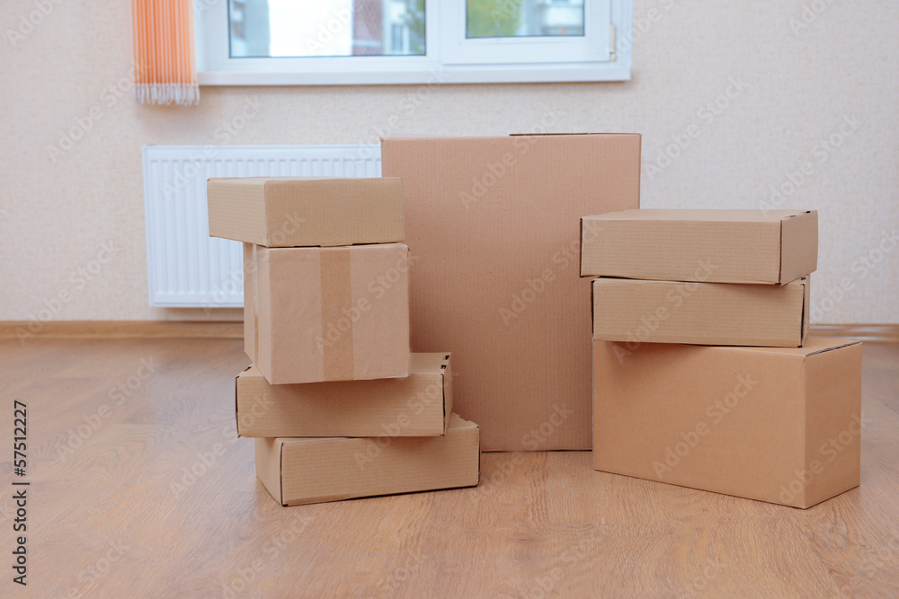 Empty room with stack of cartons: moving house concept Empty room with stack of cartons: moving house concept