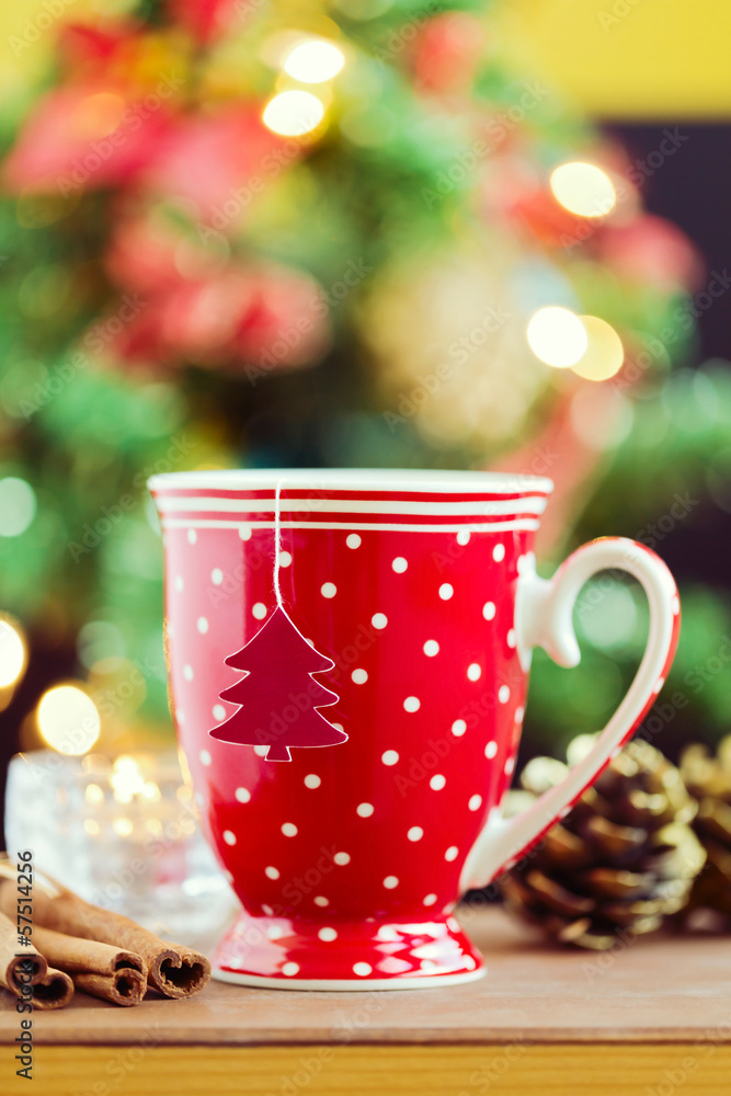 Tea cup with paper Christmas tree over bokeh background Tea cup with paper Christmas tree over bokeh background